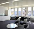 kitchen area with white cabinets, table, chairs, windows