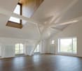 empty room, wooden floor, white walls, white beams, windows, skylights