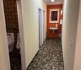 tiled flooring, two urinals, sink, trash bin