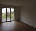empty room, wooden floor, sliding glass doors, white walls, radiator, power outlets