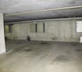 underground parking lot, concrete walls, numbered parking spots, electrical boxes, motorcycle