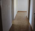 Empty hallway with wooden floor and white walls