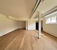 empty room, wooden floor, white walls, pipes on ceiling, window