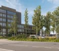 modern office building, multiple floors, large windows, parking area