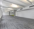 modern, empty, clean, concrete floors, white walls, high ceiling, fluorescent lighting, windows, yellow door