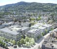 modern office building, glass facade, solar panels on the roof, surrounded by trees and other buildings, city view