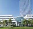 Modern office building with glass facade, multiple floors, and a central entrance.