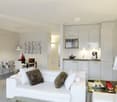 Modern living room with white couch, white kitchen cabinets, glass dining table, decorative objects, modern flooring, and a silver floor lamp
