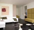 white couch, side table, decorative objects, decorative artwork, yellow couch, carpet