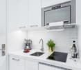 compact kitchen, white cabinets, modern appliances, sink, electric stove, dishwasher, microwave