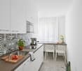 White kitchen, modern design, countertop, sink, stove, microwave, chairs, basket with vegetables