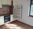 Spacious kitchen with beige cabinets, tiled floor, oven, and refrigerator