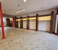 Empty room, tiled floor, wooden columns, ceiling lights, shelves, metal column