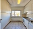 white cabinets, floor-to-ceiling windows, tiled flooring, modern kitchen design, stainless steel sink and dishwasher