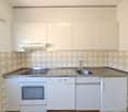 White kitchen cabinets, tiled backsplash, stainless steel appliances including oven and dishwasher, sink with countertop