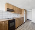 Spacious kitchen with wooden cabinets, tiled backsplash, electric stove, and a dishwasher