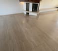 Hardwood flooring, white walls, fireplace with wooden mantel and decorative grate