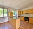 kitchen with island, wooden cabinets, granite countertop, electric stove, dishwasher, windows with views, radiator