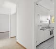 Open layout, granite countertops, double sink, built-in oven and dishwasher, tiled floor, white cabinetry, window