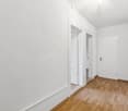 empty hallway, white walls, wooden floor, two doors