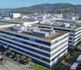 multiple floors, large parking lot, grass-covered roofs, modern office architecture