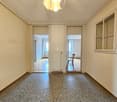 Hallway with 3 doors, radiator, gray floor, light ceiling, white walls