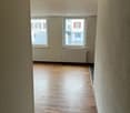 empty room, wooden floor, white walls, windows, white radiator, daylight