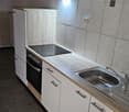 Modern Kitchen, tiled floor, white walls, gas stove, integrated dishwasher, oven, sink with faucet, tiled countertop