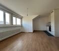 empty room, wooden floor, white walls, large windows, kitchen with oven and sink