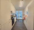 modern kitchen, white cabinets, black appliances, tiled floor, large windows, dishwasher