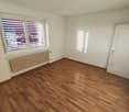 empty room, wooden floor, white walls, window with blinds, radiator