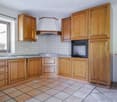 wooden cabinets, granite countertop, integrated sink, modern oven, natural light from window