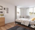 Double bed, bedside table, side tables, large windows, wooden floor, wooden chest of drawers, picture frames on the wall, plant, candles.