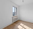 empty room, white walls, wooden floor, white radiator, window with view