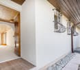 white house, wooden door, arch entrance, white floor, small garden, balcony