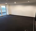 empty room, white walls, black floor, sliding glass doors, balcony, view of the outside