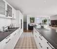 modern white cabinets, black countertops, white tiles, modern kitchen appliances, decorative elements