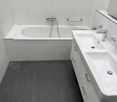 modern bathroom, white tiles, white bathtub, white sink, white vanity with drawers, modern faucet