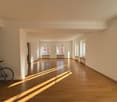 large room, wooden floors, white walls, large windows, sunlight