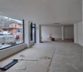 empty room, with large window, pillar, empty floor, a pile of material on the ground