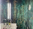Bathroom with green walls, seahorses and corals wallpaper, double sink, mirror, toilet