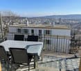 Balcony with table and chairs, metal railing, city view
