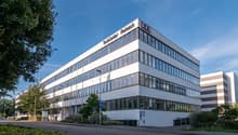 TechCenter Reimach is a 4 story white office building with glass windows, located on the side of the road