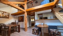 Wooden beams, table, chairs, stools, microwave, open staircase