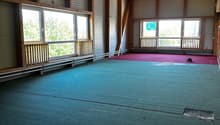 large room, wooden beams, large windows, green carpet, red carpet
