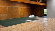 large room, wooden beams, unfinished walls, green carpet, wooden floor, skylights