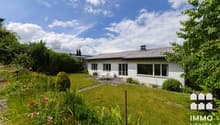 / a large white house with a garden and lawn in the countryside