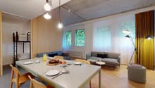 Wooden floor, dining table with cutlery and plates, blue sofa, and couch, lamps