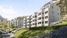 Modern residential complex on slope, balconies, green landscape, mountain view