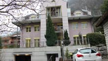 3 story house, pink and yellow painted, ground floor parking, balcony